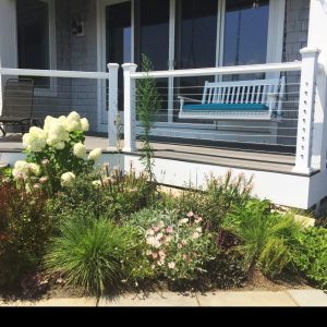 Porch with a swing next to a beautiful landscaped garden bed. Porch with a swing next to a beautiful landscaped garden bed.